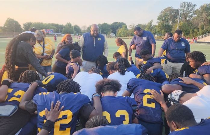 Coach Carr and the team huddled on the football field
